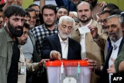 Iranian presidential candidate and ultraconservative former nuclear negotiator Saeed Jalili, center, casts his ballot at a polling station in Tehran on July 5, 2024.