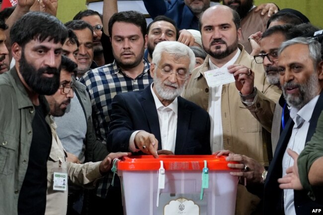 Capres Iran dan mantan negosiator Saeed Jalili (tengah) memasukkan surat suara di sebuah TPS di Teheran Iran, Jumat, 5 Juli 2024. (Foto: Rahed Homavandi/AFP)