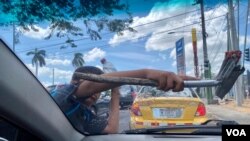 Un niño en Managua gana algún dinero para su familia limpiando parabrisas de vehículos en plena vía pública.