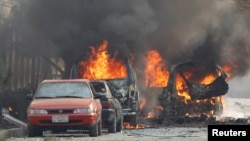 Beberapa mobil terbakar akibat ledakan saat kawanan bersenjata menyerang kantor "Save the Children" di Jalalabad, Afghanistan, Rabu (24/1). 