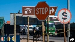 Trucks wait to enter Zimbabwe from South Africa at a Bridge border post near Musina, South Africa, Tuesday, July 2, 2020. 