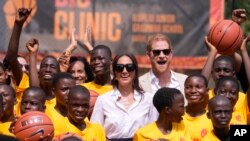 FILE— Prince Harry and Meghan, center, pose for a photograph with children during the Giant of Africa Foundation at the Dream Big Basketball clinic in Lagos Nigeria, May 12, 2024. 