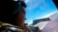 FILE - Sergeant Trent Wyatt looks out an observation window aboard a Royal New Zealand Air Force (RNZAF) P3 Orion maritime search aircraft as it flies over the southern Indian Ocean looking for debris from missing Malaysian Airlines flight MH370.
