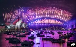 Fireworks explode over the Sydney Opera House and Harbour Bridge as New Year celebrations begin in Sydney, Australia, Dec. 31, 2020. Authorities advised revelers to watch the fireworks on TV as New South Wales and Victoria battle COVID-19 outbreaks.