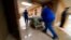 FILE - Medical staff move a COVID-19 patient who died to a loading dock to hand off to a funeral home van, at the Willis-Knighton Medical Center in Shreveport, La., Aug. 18, 2021.