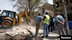 People gather at the site of a car bomb attack in the Karrada district in Baghdad, Iraq, Sept. 6, 2016. 