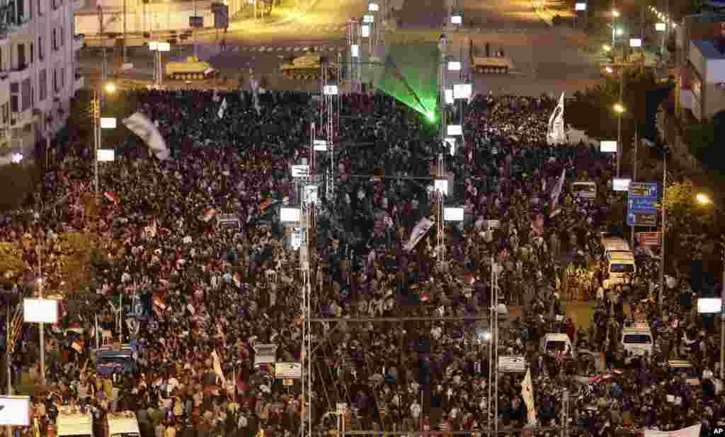 Egyptian army tanks secure the perimeter of the presidential palace while protesters gather chanting slogans against President Mohammed Morsi, in Cairo, Egypt, December 7, 2012.