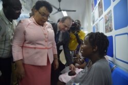 FILE - Minister of Public Health and Population of Haiti, Marie-Greta Roy Clément, left, and Minister of Health of Brazil Ricardo Barros, center, visit the Dr. Zilda Arns Lieu Hospital in Bon Repos, Port-au-Prince, June 23, 2017.