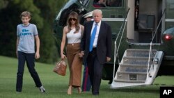 President Donald Trump, first lady Melania Trump, and their son Barron Trump walk from Marine One across the South Lawn to the White House in Washington, June 11, 2017.