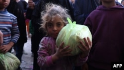 A Palestinian girl carries a bag of bread outside a bakery in Khan Younis on the southern Gaza Strip, Oct. 29, 2024, amid the ongoing war between Israel and the Palestinian militant group Hamas.