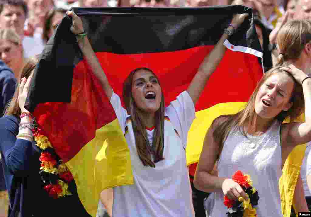 Para penggemar bola bersorak untuk tim sepakbola nasional Jerman ketika merayakan kemenangan tim tersebut dalam Piala Dunia Brazil 2014, di tempat nobar Fan Mile, di Berlin, 15 Juli 2014.