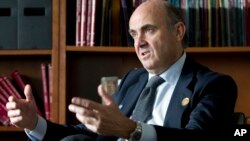FILE - Spain's Economy Minister Luis de Guindos speak during an interview with The Associated Press at the IMF headquarters in Washington, April 17, 2015. 