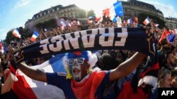 Para pendukung tim sepak bola Perancis meneriakkan slogan-slogan saat berkumpul di 'zona fan' di Paris, 10 Juli 2018.