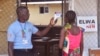 FILE - A unidentified family member (R) of a 10-year-old boy who contracted Ebola, has her temperature taken by a health worker at an Ebola clinic on the outskirts of Monrovia, Liberia, Nov. 20, 2015. 