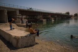 Residents enjoy the cold waters of the Euphrates River during the hot days of summer, Aug. 25, 2019 in Raqqa, Syria. (Yan Boechat/VOA)