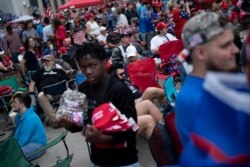 Un vendedor vende recuerdos mientaras los partidarios del presidente Donald Trump aguardan para su acto de campaña en Tulsa, Oklahoma, el sábado, 20 de junio de 202. AFP