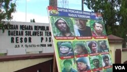 Baliho memuat daftar buronan kasus terorisme di depan markas kepolisian resor Poso. (VOA/Yoanes Litha)