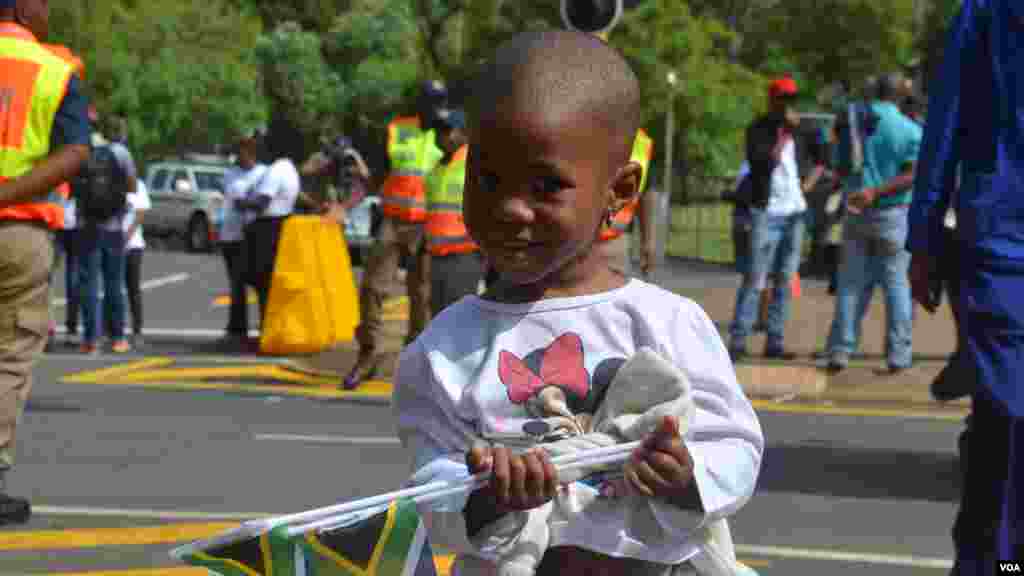 Un niño sale a la calle a ver pasar el cortejo. [Foto: Ramón Taylor, VOA].