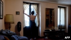 FILE - Mexican sex worker, Alenca, looks through her window before starting her working day at her home in Madrid on April 28, 2020 amid a national lockdown to prevent the spread of the COVID-19 disease. 