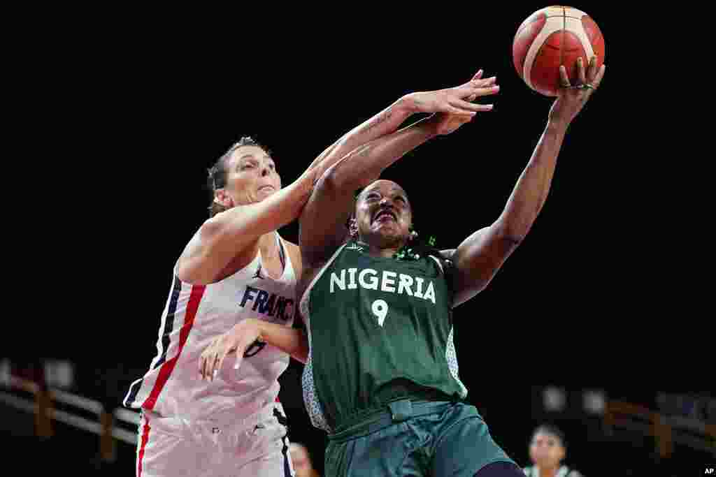 Nigeria&#39;s Aisha Mohammed (9) drives to the basket against France&#39;s Helena Ciak (8) during a women&#39;s basketball game at the 2020 Summer Olympics, Friday, July 30, 2021, in Saitama, Japan. (AP Photo/Eric Gay)