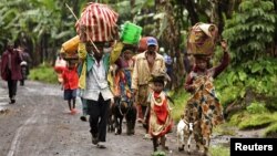 Internally displaced Congolese carry their belongings as they flee to safety, fearing renewed clashes between government forces and rebels in eastern Democratic Republic of Congo, May 21, 2012.