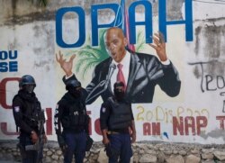 Policía pasa frente al mural que muestra al presidente haitiano Jovenel Moise, cerca de la residencia del líder donde fue asesinado por hombres armados en Port-au-Prince, Haití, el miércoles 7 de julio de 2021.