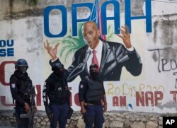 Policía pasa frente al mural que muestra al presidente haitiano Jovenel Moise, cerca de la residencia del líder donde fue asesinado por hombres armados en Port-au-Prince, Haití, el miércoles 7 de julio de 2021.