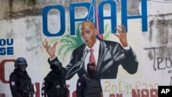 La policía pasa frente a un mural que muestra al presidente haitiano Jovenel Moise, cerca de la residencia del líder donde fue asesinado por hombres armados en Puerto Príncipe, Haití, el miércoles 7 de julio de 2021.