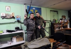 FILE - Members of the Russian Imperial Movement, a nationalist group in Russia, pose for a picture with weapon simulators at a training base in Saint-Petersburg, Feb. 28, 2015.