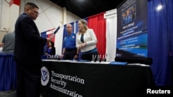 A veteran talks about job opportunities with a representative from Transportation Security Administration, TSA, at a military job fair in Sandy, Utah, U.S., March 26, 2019. 