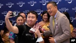 Turis China berswa-foto bersama Perdana Menteri Thailand Srettha Thavisin, kanan, saat mereka tiba di Bandara Internasional Suvarnabhumi di Provinsi Samut Prakarn, Thailand, Senin, 25 September 2023. (Foto: AP)