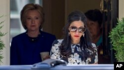 Asisten dekat Hillary Clinton, Huma Abedin, berjalan mendahului kandidat presiden AS dari Partai Demokrat itu rumah Clinton di Washington. (Foto: Dok)