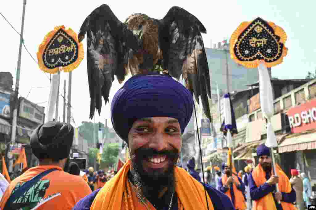 A Sikh devotee with an eagle takes part in a religious procession on the eve of the birth anniversary of the fourth Sikh Guru Ramdas in Amritsar.