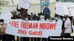 Supporters of Tanzania's opposition party Chadema leader Mbowe holding a banner chant slogans, in Dar Es Salaam