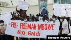 Supporters of Tanzania's opposition party Chadema leader Mbowe holding a banner chant slogans, in Dar Es Salaam, Aug 5, 2021.