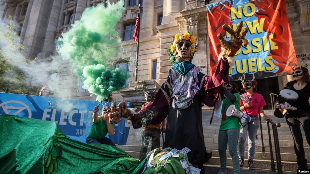 资料照片：2022年4月22日，气候组织“反抗灭绝”的活动人士在美国华盛顿约翰·威尔逊哥伦比亚特区政府大楼前示威，要求停止所有新的化石燃料基础设施。 （路透社）(photo:VOA)