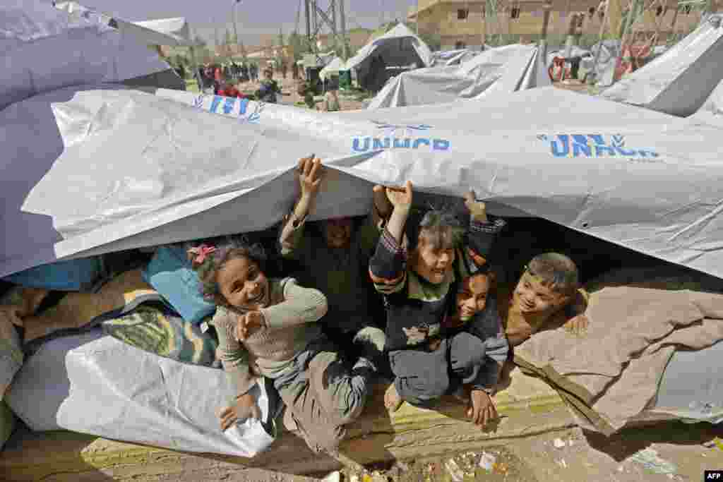 Syrian children, evacuated from rebel-held areas in the Eastern Ghouta, are seen playing at a shelter in the government-controlled Adra district, on the northeastern outskirts of the capital Damascus.
