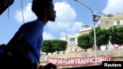 Sebuah spanduk bertuliskan "Setop Perdagangan Manusia" terpampang saat kapal penyelamat migran, MV Aquarius, mendekati pelabuhan Valletta, Malta, 15 Agustus 2018. (Foto: Reuters)