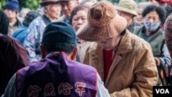 台灣人安基金會的工作人員對申請者做簡單的身份識別後即送出午餐邀請單。 （美國之音記者方正拍攝）