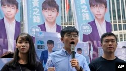Hong Kong democratic activists, Joshua Wong, center, accompanied by Agnes Chow and pro-democracy lawmaker Au Nok-hin, announced plans to contest local elections, in Hong Kong, Sept. 28, 2019.