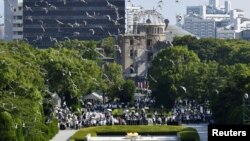 Burung dara beterbangan di atas Peace Memorial Park dengan latar belakang Kubah Bom Atom dalam upacara peringatan ke-73 pemboman atom kota di Hiroshima, Jepang barat, 6 Agustus 2018. (Foto: Kyodo/via REUTERS).