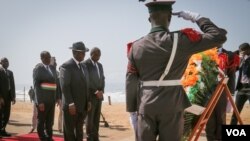 Le président ivoirien Alassane Ouattara se prépare à déposer une couronne de fleurs en mémoire des personnes tuées dans l'attaque jihadiste sur une plage de Grand Bassam, 16 mars 2016. (E. Iob / VOA)