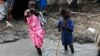 Children walk through mud in an internally displaced persons camp inside the United Nations base in Malakal, South Sudan, July 23, 2014.