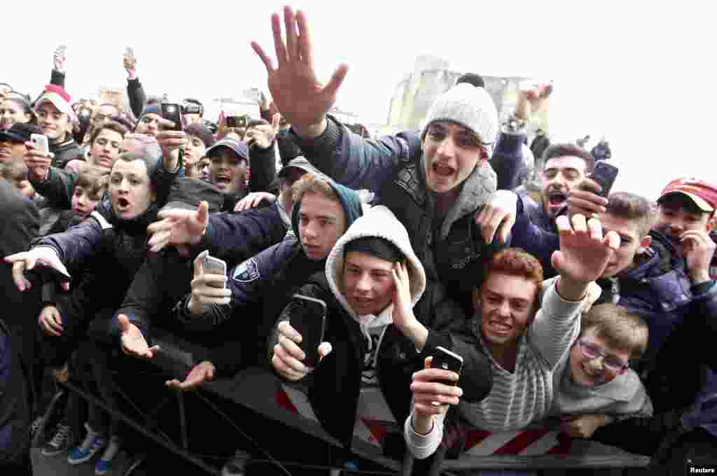 Supporters gather in the street as former Argentine soccer star Diego Maradona leads a news conference in Naples, Italy. 