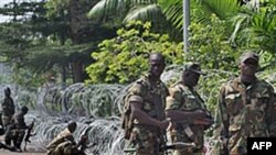 Armed members of the New Forces adopt combat positions near the hotel that houses the rival government declared by Alassane Ouattara in Abidjan, Ivory Coast, on Dec 13, 2010
