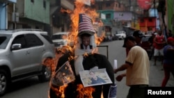 Des militants pro-gouvernement mettent en feu une photo de Donald Trump, à Caracas, le 16 avril 2017.