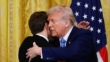 US President Donald Trump and French President Emmanuel Macron embrace at the end of a joint press conference in the East Room to the White House in Washington, DC, on February 24, 2025. (Photo by Ludovic MARIN / AFP)