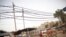 Potters rest on the roadside, under the overhead power cables at Gurgaon, on the outskirts of New Delhi June 17, 2012.
