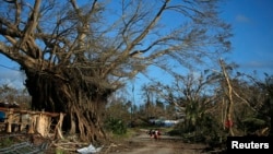 People walk through a street in Lenakel town after Cyclone Pam struck Tanna, about 200 kilometers from Port Vila, capital city of the Pacific island nation of Vanuatu, March 17, 2015. 