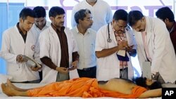 A doctor inspects the health of Indian yoga guru Baba Ramdev at Ramdev's ashram in Haridwar, India, June 10, 2011.